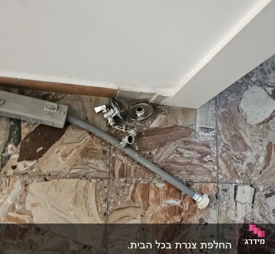 חלקי צנרת על רצפה עם אריחים צבעוניים